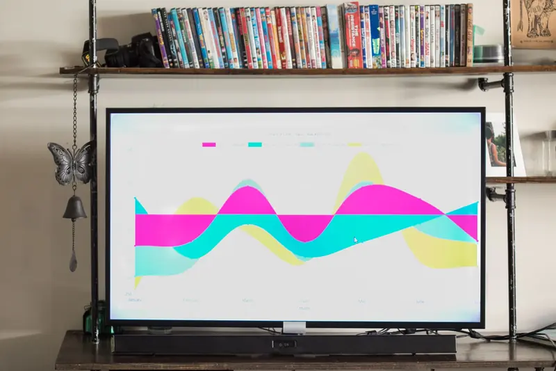 Modern living room with TV showing a vibrant, colorful graph and a shelf full of DVDs