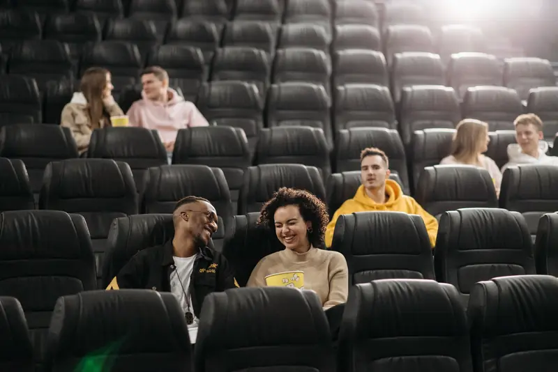 Young adults having fun in an empty movie theater with popcorn