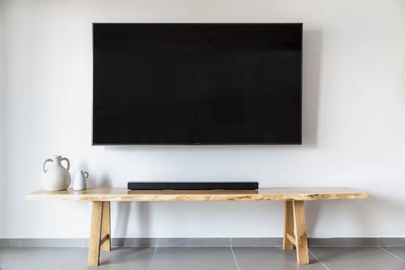 Stylish minimalist living room featuring a wall-mounted flat screen TV and wooden console