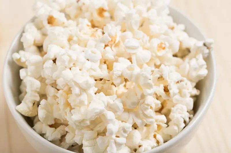 Close-up of freshly popped popcorn in a white bowl, perfect for a movie night snack