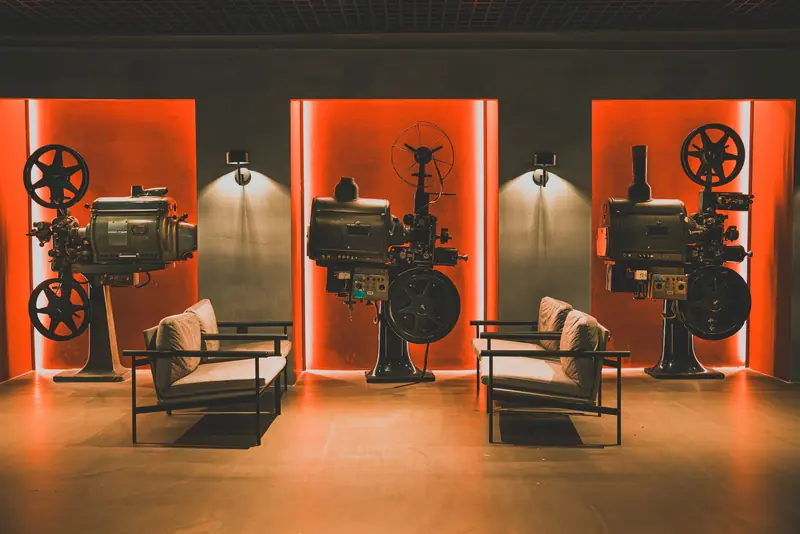 A cozy retro cinema room showcasing vintage film projectors and comfortable seating