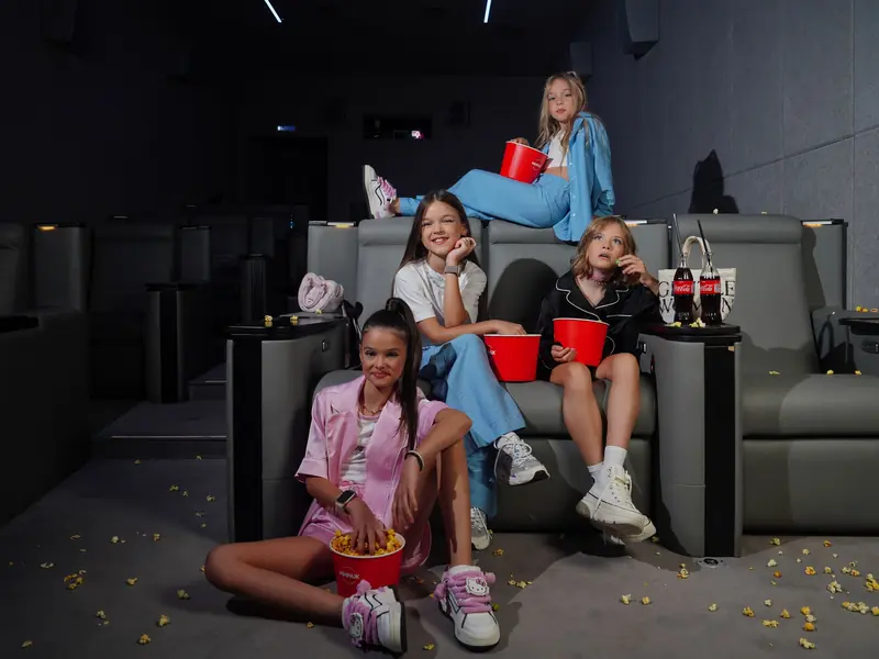 Group of children in a cozy home theater enjoying a movie with snacks
